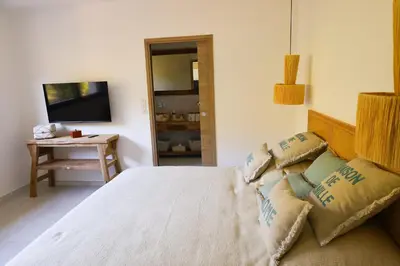a bedroom with a large bed and a television at Villa Aberia Di Santa Lucia in Sainte-Lucie de Porto-Vecchio