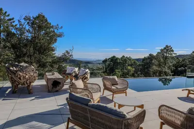 a patio with chairs and a table and a pool at Villa Aberia Di Santa Lucia in Sainte-Lucie de Porto-Vecchio