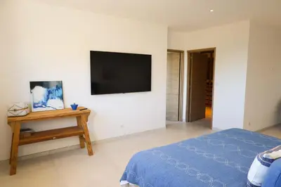 a bedroom with a bed and a tv on a wall at Villa Aberia Di Santa Lucia in Sainte-Lucie de Porto-Vecchio
