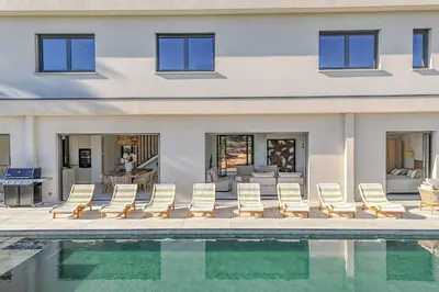 a group of chairs sitting next to a swimming pool at Villa Aberia Di Santa Lucia in Sainte-Lucie de Porto-Vecchio