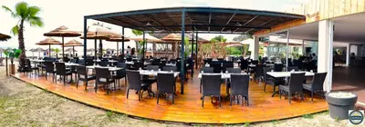 a restaurant with tables and chairs and umbrellas at Bungalow 4 people - Marea Resort in Santa-Lucia-di-Moriani