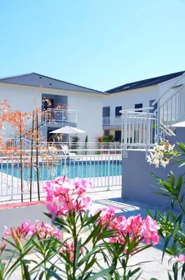 a resort with a pool and flowers at Bungalow 4 people - Marea Resort in Santa-Lucia-di-Moriani