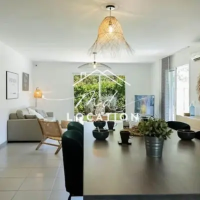a living room with a table and a couch at Villa route de Palombaggia in Porto-Vecchio