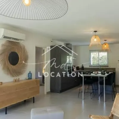 a living room with a table and a dining room at Villa route de Palombaggia in Porto-Vecchio
