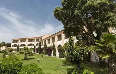 an exterior view of a building with trees and bushes at Apartment T2 - 200 m from the sea in Linguizzetta