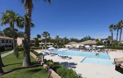 a pool at a resort with palm trees and people at Apartment T2 - 200 m from the sea in Linguizzetta