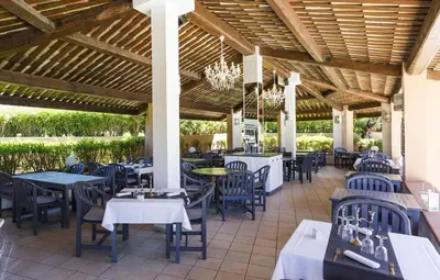 a restaurant with tables and chairs and a wooden ceiling at Apartment T2 - 200 m from the sea in Linguizzetta