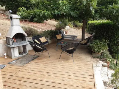 a wooden deck with chairs and a fireplace at La Palombière - La Bruyère in Casalabriva