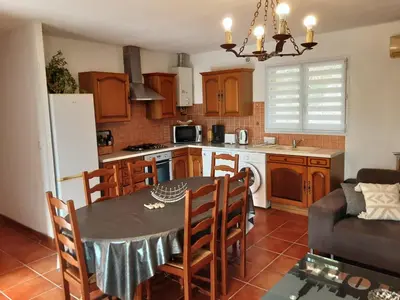 a kitchen and dining room with a table and chairs at La Palombière - La Bruyère in Casalabriva