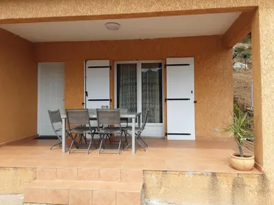 a dining table and chairs on a patio at La Palombière - La Bruyère in Casalabriva