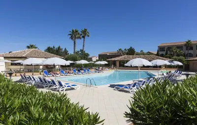 a swimming pool with lounge chairs and umbrellas at T2 - next to the sea in Linguizzetta