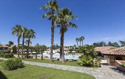 a resort with a swimming pool and palm trees at T2 - next to the sea in Linguizzetta