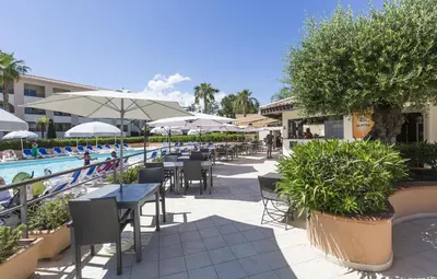a patio with tables and chairs next to a swimming pool at T2 - next to the sea in Linguizzetta