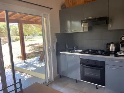 a kitchen with a sink and a stove top oven at Cozy mini villa proche plages, calme & activés in Bonifacio