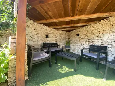 a group of benches sitting under a stone wall at Cozy mini villa proche plages, calme & activés in Bonifacio