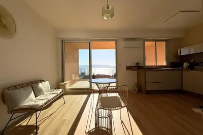 a living room with a couch and a table at Bright studio with sea view in Ajaccio in Ajaccio