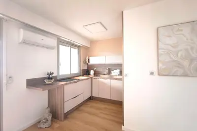 a kitchen with white cabinets and a sink and a window at Bright studio with sea view in Ajaccio in Ajaccio