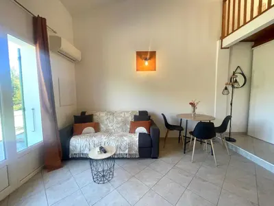 a living room with a bed and a table and a table at Charmant Duplex à la campagne in Riventosa