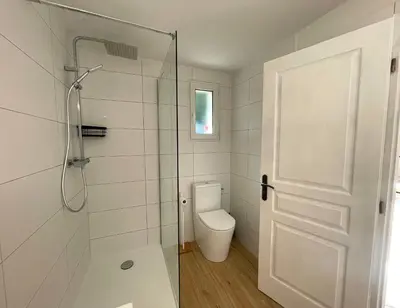 a bathroom with a toilet and a glass shower door at Charmant Duplex à la campagne in Riventosa