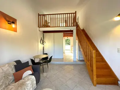 a living room with a couch and a staircase at Charmant Duplex à la campagne in Riventosa
