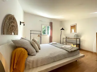 a bedroom with a bed with white sheets and pillows at Charmant Duplex à la campagne in Riventosa