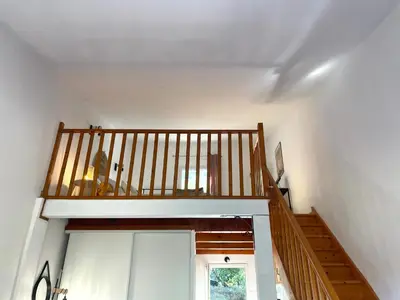 a staircase in a house with a wooden railing at Charmant Duplex à la campagne in Riventosa