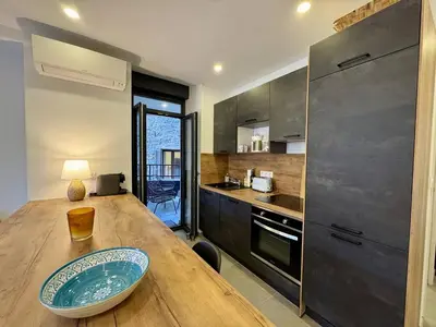 a kitchen with a wooden table with a bowl on it at Magnifique T3 tout confort in Propriano