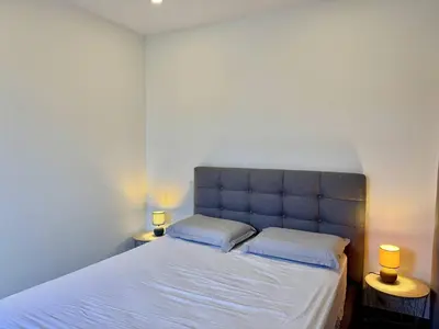 a bedroom with a large bed with two lamps on tables at Magnifique T3 tout confort in Propriano