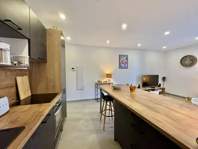 a kitchen with a wooden counter top in a room at Magnifique T3 tout confort in Propriano