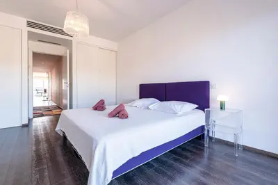 a bedroom with a large white bed with red pillows at Strada Agosta - Terrasse vue mer in Albitreccia