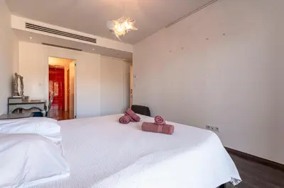 a bedroom with a white bed with two pink towels on it at Strada Agosta - Terrasse vue mer in Albitreccia