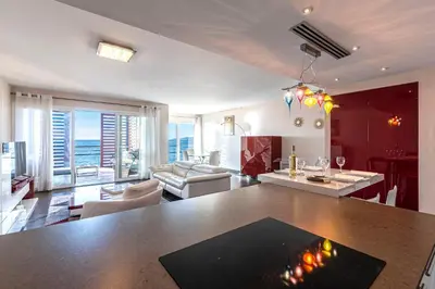 a kitchen and living room with a table and chairs at Strada Agosta - Terrasse vue mer in Albitreccia