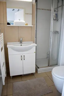 a bathroom with a white sink and a shower at Appartement Cosy Port de Porto-Vecchio in Porto-Vecchio