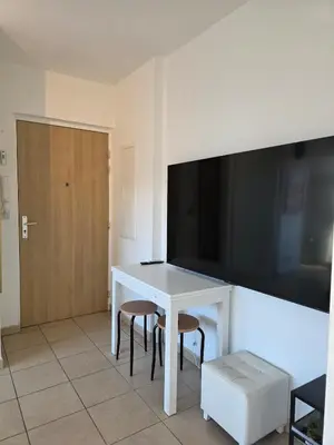 a white table with two chairs and a television on a wall at Appartement Cosy Port de Porto-Vecchio in Porto-Vecchio