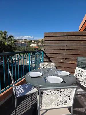 a table and chairs on a balcony with a view at Appartement Cosy Port de Porto-Vecchio in Porto-Vecchio