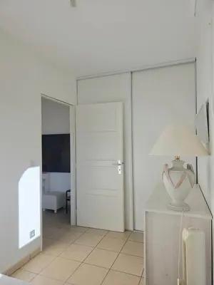 a white room with a lamp on a dresser at Appartement Cosy Port de Porto-Vecchio in Porto-Vecchio