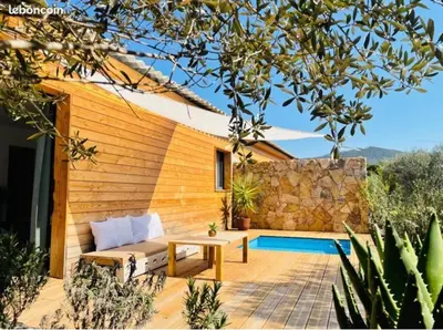 a patio with a table and a pool at Villa Marilou avec petite piscine privée in Figari