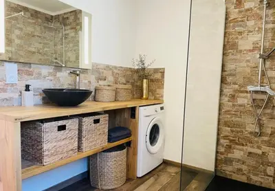 a bathroom with a sink and a washing machine at Villa Marilou avec petite piscine privée in Figari