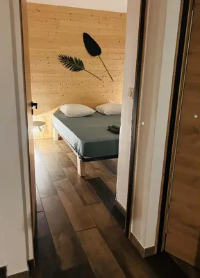 a bedroom with a bed with a wooden wall at Villa Carmen avec petite piscine privée in Figari
