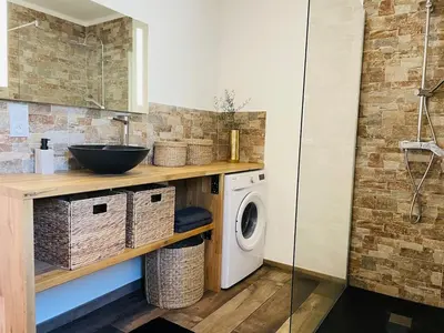 a bathroom with a sink and a washing machine at Villa Carmen avec petite piscine privée in Figari