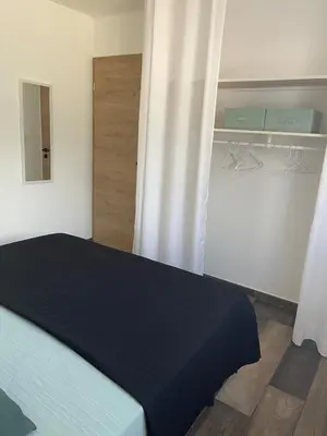 a bedroom with a blue bed and a closet at Villa Carmen avec petite piscine privée in Figari