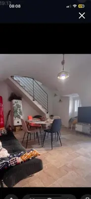 a living room with a table and a staircase at Zilia in Zilia