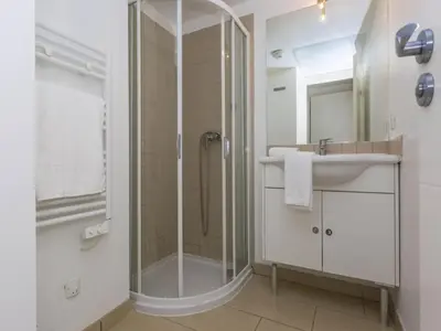 a bathroom with a glass shower and a sink at Sea-view holiday home in Solenzara in Kamiesch