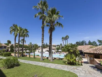 a resort with a pool and palm trees at Gorgeous apartment for 4 people with balcony in Linguizzetta