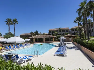 a swimming pool with blue and white chairs and palm trees at Gorgeous apartment for 4 people with balcony in Linguizzetta