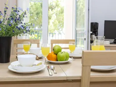 a table with a bowl of fruit and glasses of orange juice at Beautiful holiday home in Solenzara in Kamiesch