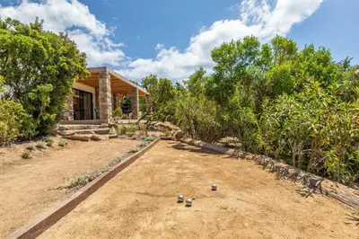 a house with a dirt road next to trees at Maison Lucciana - Santa Giulia in Porto-Vecchio