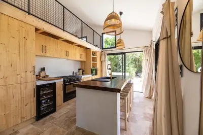 a kitchen with wooden cabinets and a large island at Maison Lucciana - Santa Giulia in Porto-Vecchio