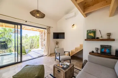 a living room with a couch and a chair at Maison Lucciana - Santa Giulia in Porto-Vecchio