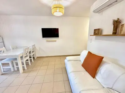 a living room with a couch and a table at Appartement 2 chambres - Rez-de-jardin - Avec piscine in Oletta